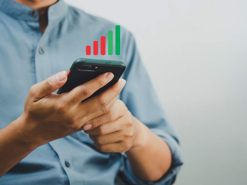 A person holding a phone with low signal bars, struggling with poor mobile reception inside a building.